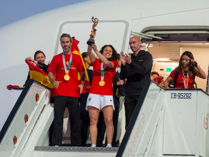 La capitana de la selección, Ivana Andrés levanta la Copa del Mundo a su llegada al aeropuerto de Barajas, con Jorge Vilda a la izquierda y Luis Rubiales a la derecha.