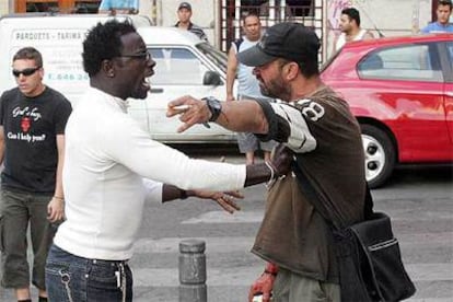 Un hombre que frecuenta la plaza increpa al supuesto asesino, cuya mano derecha, en la que lleva una lata de cerveza, está cubierta de sangre.