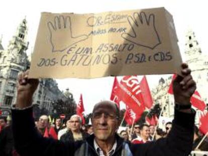 Un hombre sostiene una pancarta durante una manifestación en contra la Troika de la Unión Europea y de las medidas de austeridad. EFE/Archivo