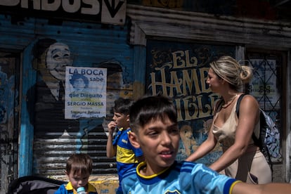 Una mujer camina con sus hijos por el barrio de La Boca.