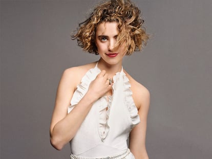 Bodi con escote halter y volante, bermudas de encaje, cinturón de perlas con cierre metálico y anillo de alta joyería,
todo de CHANEL.