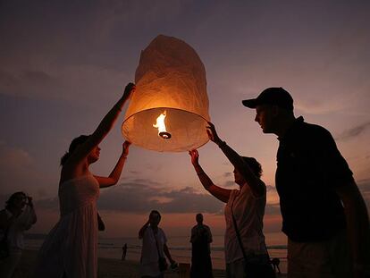 Turistas suecos alzan ayer una linterna de papel en recuerdo de las víctimas en la ciudad tailandesa de Khao Lak.