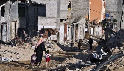 Uma mulher palestina leva uma criança pela mão entre os escombros da cidade de Gaza, no bairro de Shejaiya. Depois de 50 dias de ofensiva, Israel e Hamas aceitam um cessar-fogo definitivo na Faixa.