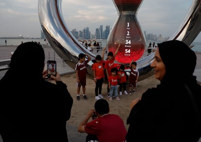 Un grupo de niños es fotografiado en el reloj de la cuenta atrás par el inicio del Mundial en Doha.