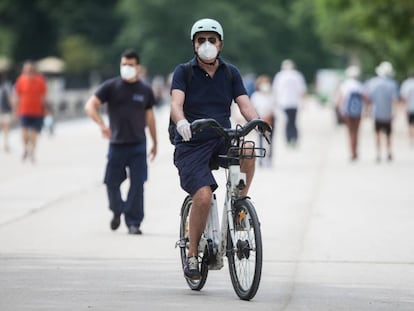 Un hombre con mascarilla y guantes monta en una BiciMad por el Retiro, el pasado 31 de mayo. 