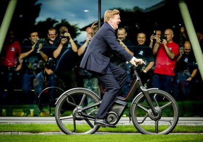 El rey holandés Guillermo Alejandro monta en un prototipo de bicicleta eléctrica 'Gazelle' durante la inauguración de una fábrica de la compañía en Dieren (Holanda).