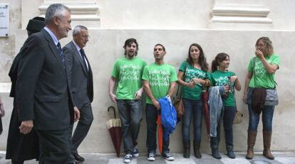 Griñán pasa frente a unos manifestantes en el acto de apertura del curso.