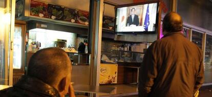 Dos chipriotas ven en una televisión a su presidente, Nikos Anastasiadis, en una comparecencia la semana pasada