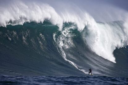 El surfista sudafricano Andy Marr toma una ola en el arrecife de coral Dungeons en el oceáno Atlántico, a las afueras de Ciudad del Cabo (Sudáfrica).