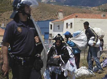 Un polica local desaloja a un grupo de personas de la zona en la que ayer murieron dos mujeres.