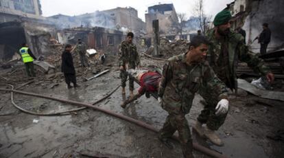 Soldados del Ejército afgano trasladan a una de las víctimas del atentado perpetrado junto al mayor mercado de la capital.