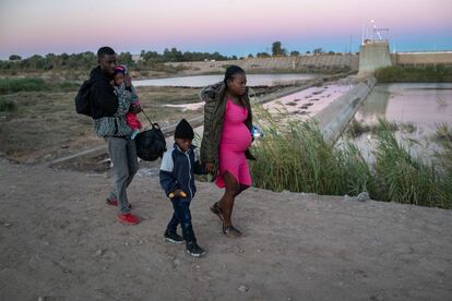 Una familia proveniente de Haití camina después de haber cruzado la frontera de Yuma, en Arizona