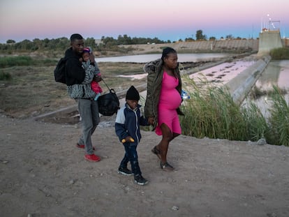 Una familia proveniente de Haití camina después de haber cruzado la frontera de Yuma, en Arizona