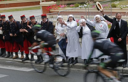 Un grupo de espectadores vestidos con atuendo de la Primera Guerra Mundial saluda al paso del pelot&oacute;n del Tour de Francia en la localidad de Amiens.