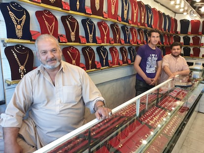 Mohsen Kayumi, con sus hijos, en la tienda de venta de oro de su propiedad, el jueves en Kabul (Afganistán).