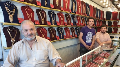 Mohsen Kayumi, con sus hijos, en la tienda de venta de oro de su propiedad, el jueves en Kabul (Afganistán).