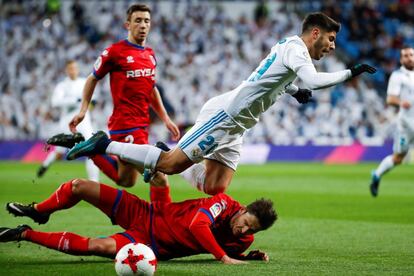 El centrocampista del Real Madrid Marco Asensio, cae ante el defensa del Numancia, Unai Elgezabal.