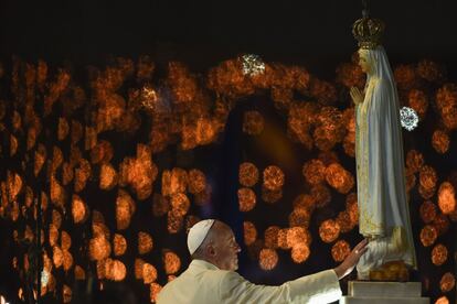El papa Francisco toca la imágen de la Virgen de Fátima, en la tradicional Bendición de las Velas, el 12 de mayo.