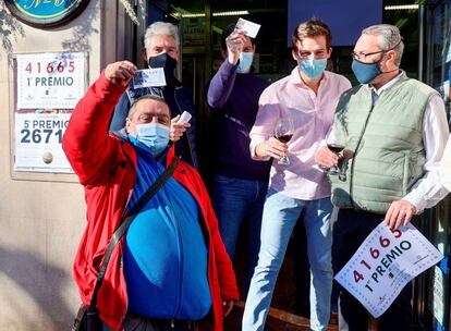 Juan Jiménez (izquierda), uno de los agraciados, muestra el décimo ganador junto a los trabajadores de la Administración de Lotería número 6 de Logroño, que ha vendido íntegramente el 41.665, primer premio del sorteo extraordinario de la lotería del Niño.