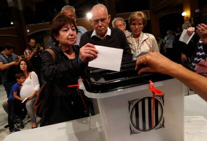 Una pareja introduce su voto en una urna en Barcelona.