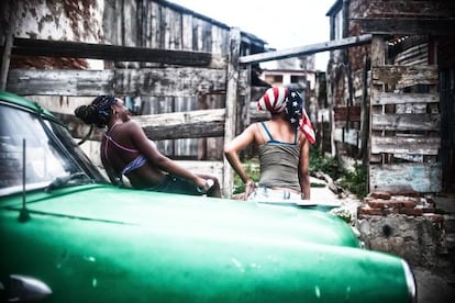 Moça traz na cabeça a bandeira dos EUA, em Santiago de Cuba.