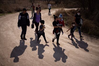 Familias caminan por un camino de tierra después de cruzar el río Grande hacia Estados Unidos desde México en Peñitas, Texas, el pasado viernes 5 de marzo.