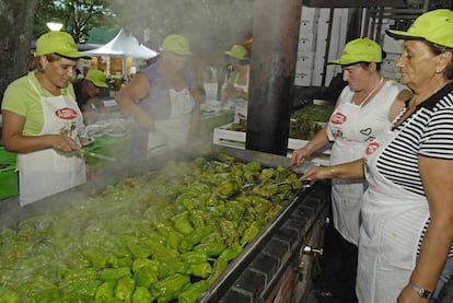 Varias mujeres cocinan durante la preparación de la fiesta del pimiento de Arnoia, en Ourense.