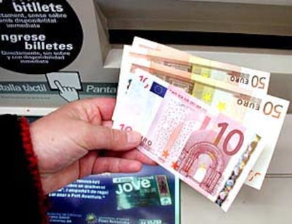 Un ciudadano de Banyoles (Girona) toca los nuevos billetes.