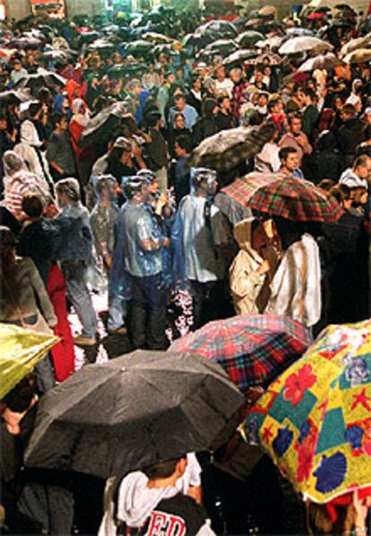 Los barceloneses  esperaron el inicio del correfoc bajo la lluvia,  en la plaza de Sant Jaume .