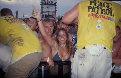 Asistentes al festival Woodstock 99 saludan a la cámara en primera fila, el 22 de julio de 1999.