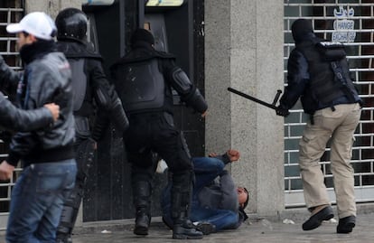 Policías golpean a un manifestante durante las protestas posteriores al funeral del opositor Belaid.