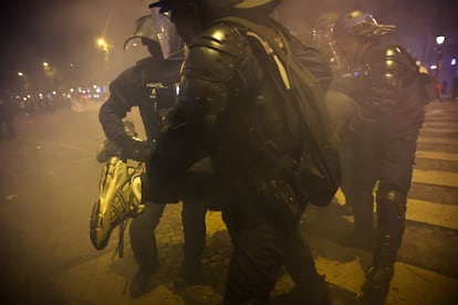 Agentes antidisturbios detienen a un hincha durante los disturbios en París, este domingo.