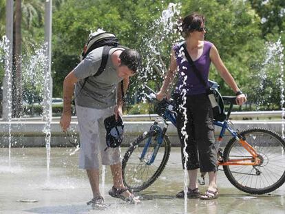 Unos jóvenes se refrescan en una fuente en Córdoba.