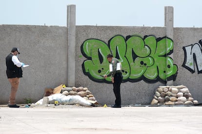Policías junto al cuerpo dejado en la barda perimetral de La Primavera, en Culiacán, en 2021.