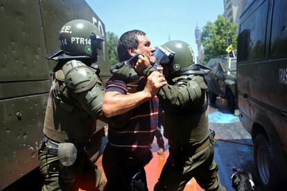 Un manifestante es detenido por policías antidisturbios durante una huelga en contra del sistema nacional de pensiones en Santiago de Chile.