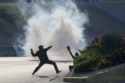 Opositores de Nicolás Maduro lanzan piedras contro los militares leales al presidente en la base aérea de Caracas, Venezuela. 