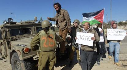 Palestinos y soldados discuten junto a una colonia cerca de Hebr&oacute;n.