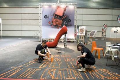 Jon Elorrieta y Saioa Aresti, estudiantes de Bellas Artes de la UPV, trabajan en el pabellón que el colectivo artístico Antikythera ha instalado en la Bienal de Máquina Herramienta en el BEC.