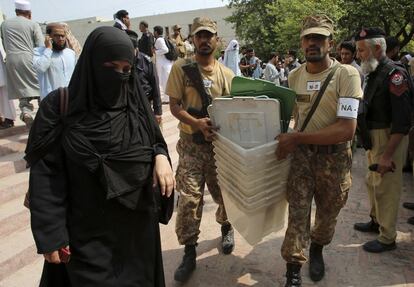 Soldados paquistaníes ayudan a cargar las urnas hasta el colegio electoral en Peshawar (Pakistán).