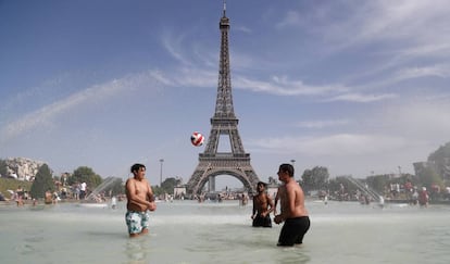 Jóvenes junto a la Torre Eiffel durante la ola de calor de la semana pasada.
