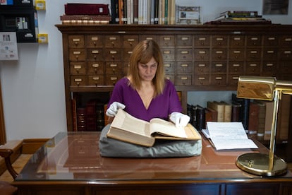 La investigadora Ane Galindo sostiene uno de los libros censurados de la Biblioteca Histórica de Santa Cruz, en Valladolid.