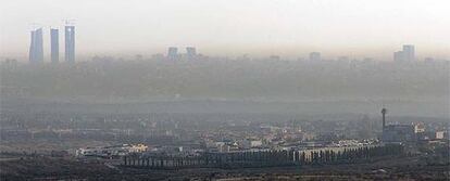 Vista aérea con las torres de la Ciudad deportiva (a la izquierda) y el magma de la contaminación abrazando a Madrid.