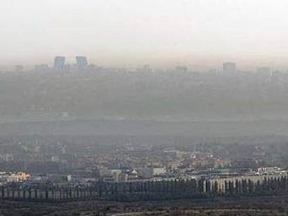 Vista aérea con las torres de la Ciudad deportiva (a la izquierda) y el magma de la contaminación abrazando a Madrid.