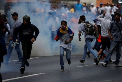 Manifestantes de la oposición se enfrentan con militares en el este de Caracas, durante una protesta contra el gobierno del presidente Nicolás Maduro. En la imagen, manifestastes huyen del gas lacrimógeno.