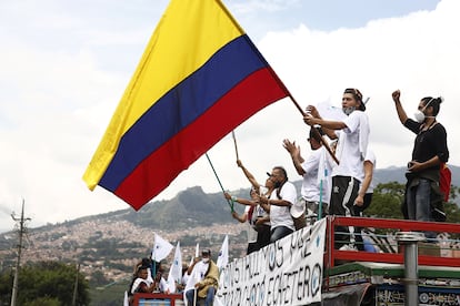 Exguerrilleros ondean banderas durante una peregrinación por la paz, en la ciudad de Medellín