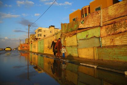 Una familia palestina camina por una calle con charcos después de llover en el campo de refugiados de Al-Shatee, en Gaza.