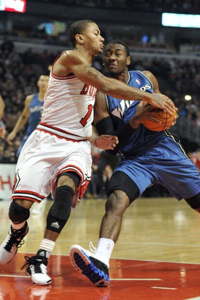 John Wall, a la derecha, intenta anotar frente a Derrick Rose.