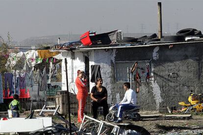 Una familia, frente a una de las chabolas existentes en el distrito de Villaverde.