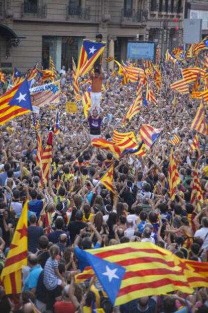 Uns manifestants del pasat 11 de setembre fan un pilar tot enlairant una estelada.