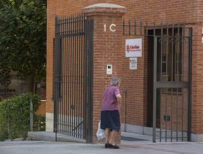 Una mujer mayor pasa por delante de la sede de Cáritas Madrid.